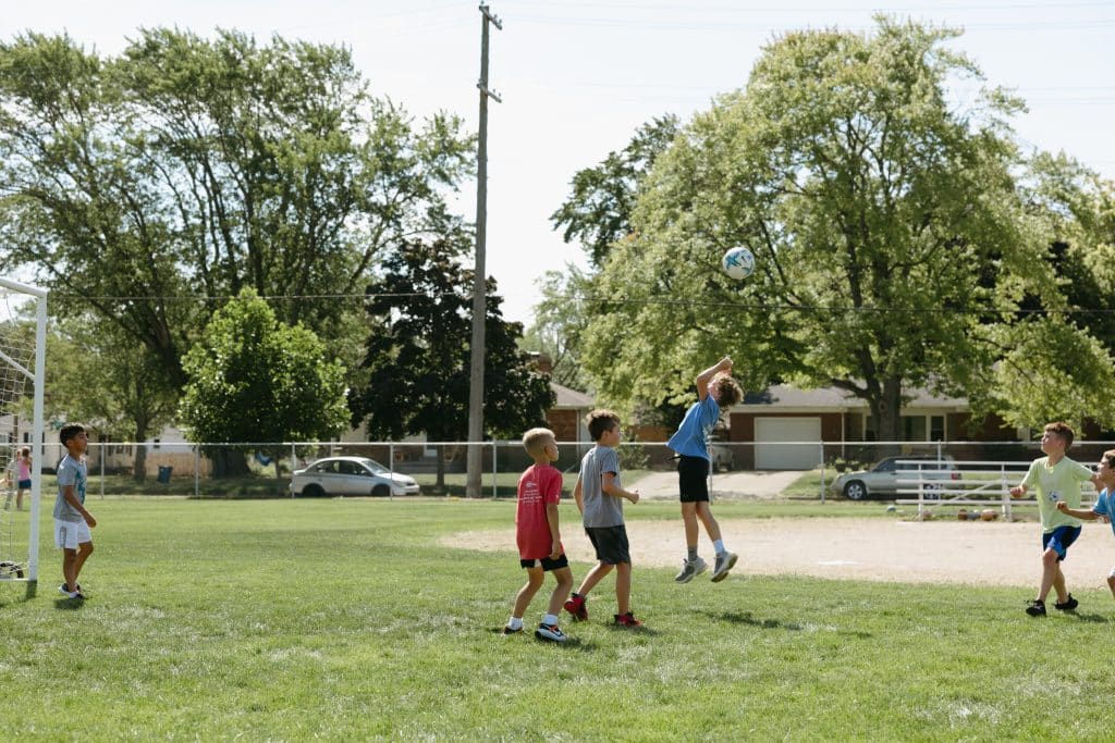 Kids outside playing soccer in a field
