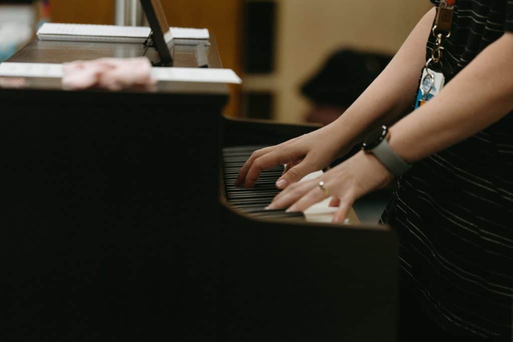 The teacher demonstrates a song on a piano