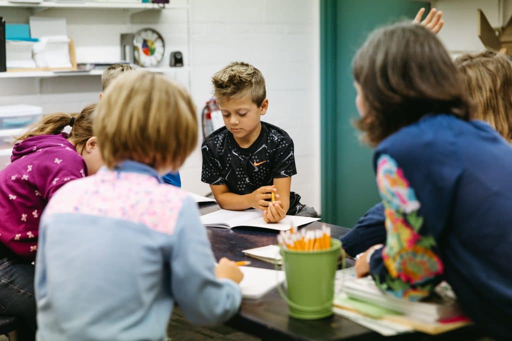 Students in class, looking over building blocks card game