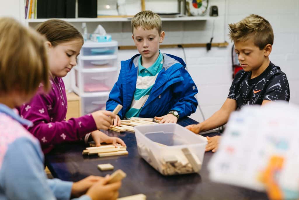 Students in class, looking over building blocks card game