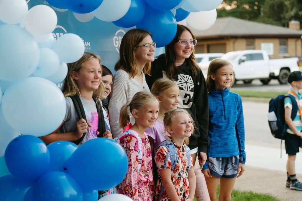 Students outside with balloons surrounding them, the balloons have the GHC logo on them